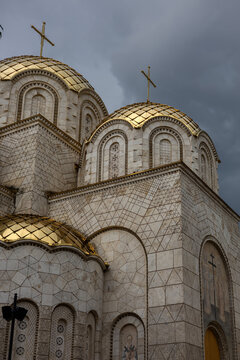golden domes and crosses of the holy trinity cathedral in arad romania against a moody dramatic cloudy sky. geometric stone facade architecture.