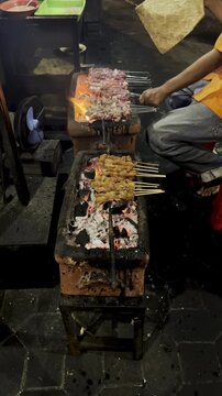 Traditional Sate Klathak Vendor Grilling Skewers Over Charcoal Fire at Night