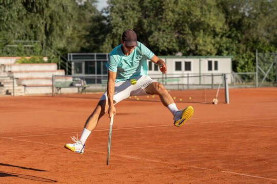 Professional tennis player performing tweener shot hitting the ball between the legs on clay court during training session. Dynamic action, advanced technique, athletic skill and competitive sport