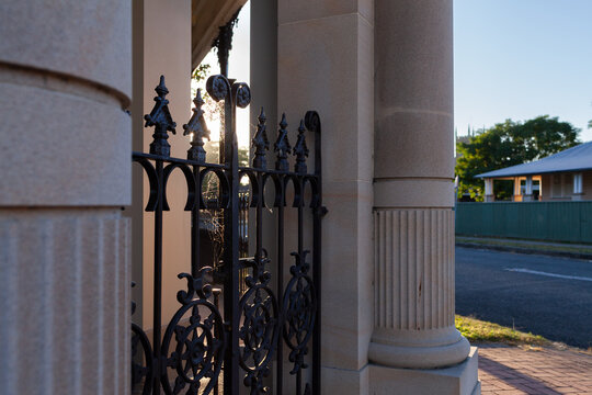 Wrought iron gate of old restored historic building with sun flare