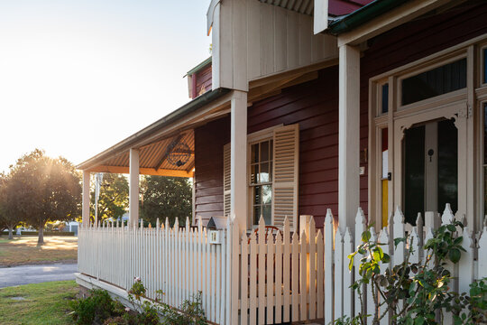 mailbox in fenced verandah of red and cream weatherboard house in county town