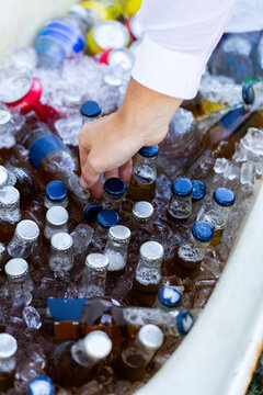 Guest getting alcohol drink from an ice filled esky at party