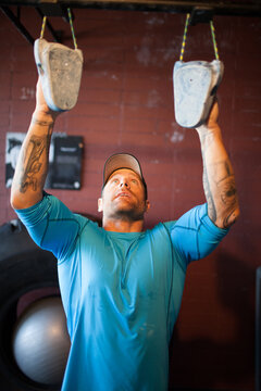Fit man with tattoos doing intense grip strength workout