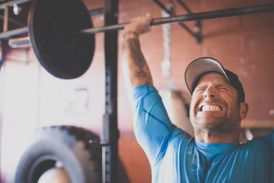 Man showing extreme effort while lifting a barbell