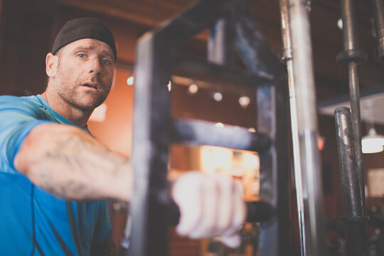 Focused man with tattoos working out at gym