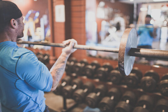 Rear view of strong man lifting weights