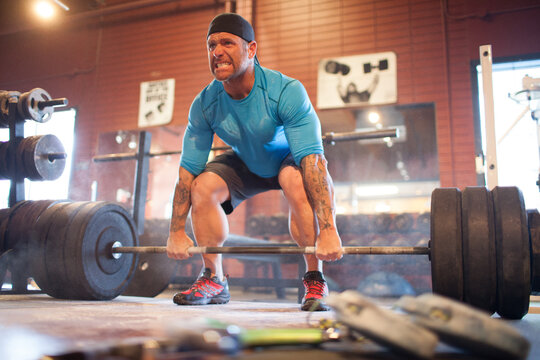 Focused man grimaces as he prepares for a heavy deadlift