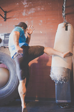Focused man with tattoos training on a heavy bag
