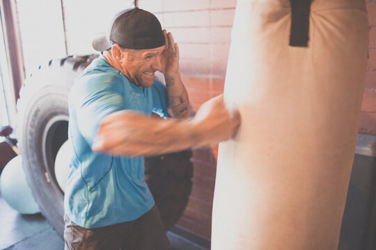 Focused man with tattoos training on a heavy bag
