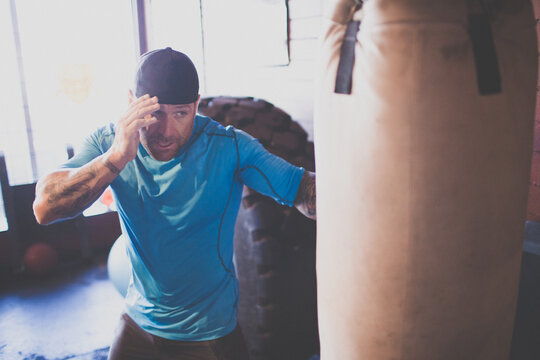 Focused man with tattoos training on a heavy bag