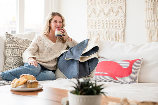 Blonde woman relaxing on a cozy white sofa