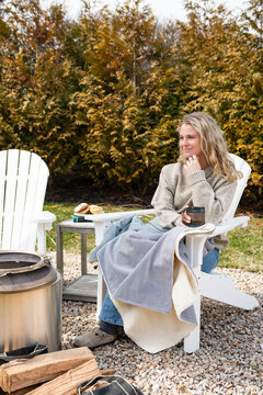 Young woman relaxing outside in an adirondack chair