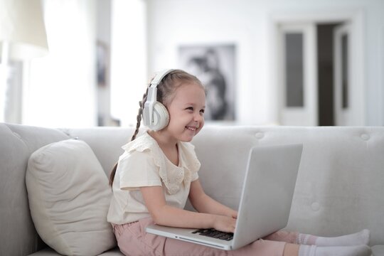 Happy girl with headphones using a laptop at home