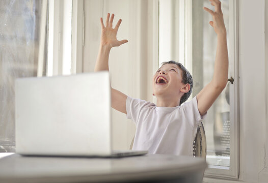 Ecstatic boy celebrating at his laptop computer