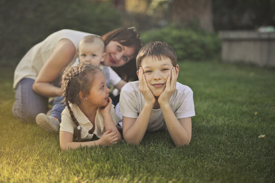 Mother and three children relaxing on grass