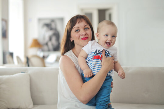 Happy mother holds her laughing baby son