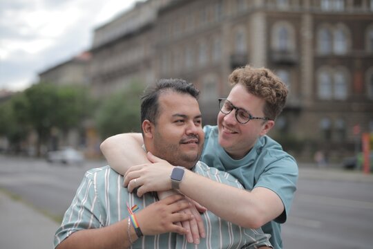 Affectionate male couple hugging outdoors in the city