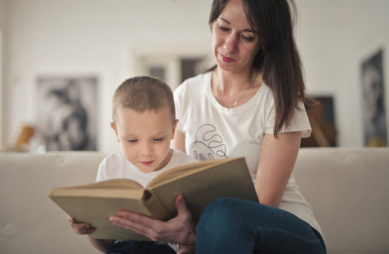 Mother and son reading a book together at home