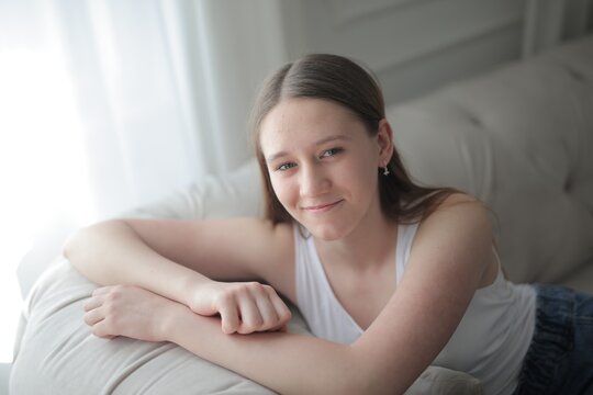 Teenage girl with a gentle smile relaxing at home