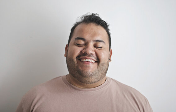 Happy plus size man smiling with his eyes closed