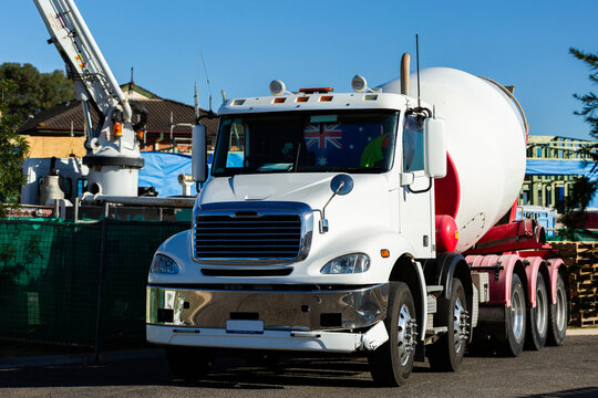 concrete mixer truck unloading at worksite with commercial building under construction