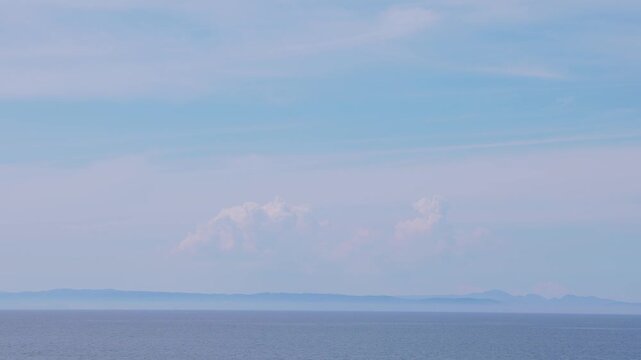 大分県佐賀関の穏やかな海と遠くの水平線に浮かぶ夏の白い雲の実景映像
