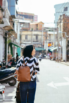 Rear view of a young Asian female tourist walking and exploring the historic Chikan Old Street in Zhanjiang, Guangdong, China