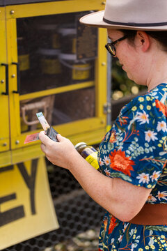 Australian person getting cash from wallet to purchase honey from roadside stall