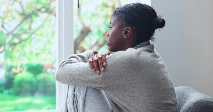 Black woman, window and overthinking in home for anxiety, mistake or fear with pressure or phobia. Trauma, panic or female person with depression in living room with stress for mental health on sofa