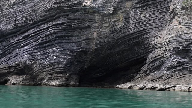 Dramatic layered coastal cliffs rising above turquoise sea in Hat Khanom&ndash;Mu Ko Thale Tai National Park. Geological rock formations shaped by millions of years of erosion.