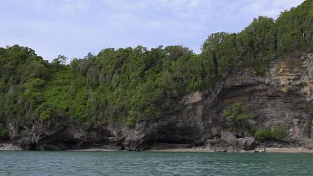 Lush limestone cliffs overlooking crystal-clear turquoise sea in Hat Khanom&ndash;Mu Ko Thale Tai National Park. Scenic tropical coastline and protected natural landscape.