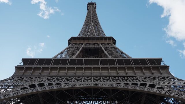 Eiffel Tower steel lattice engineering structure stands in Paris France. Historic iron arch construction architecture landmark represents European travel tourism and industrial design market.