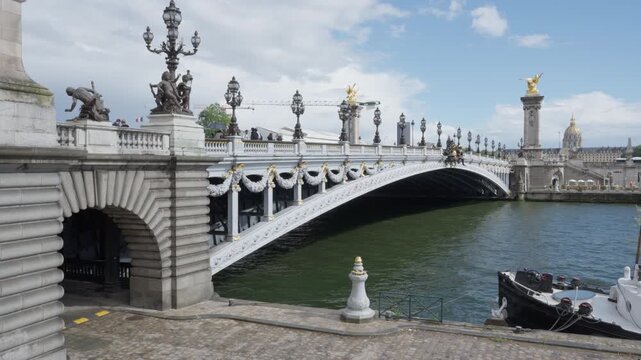Pont Alexandre III bridge spans the Seine river in Paris France. Historic ornate architecture features golden statues and stone columns for European heritage tourism travel vacation trip.