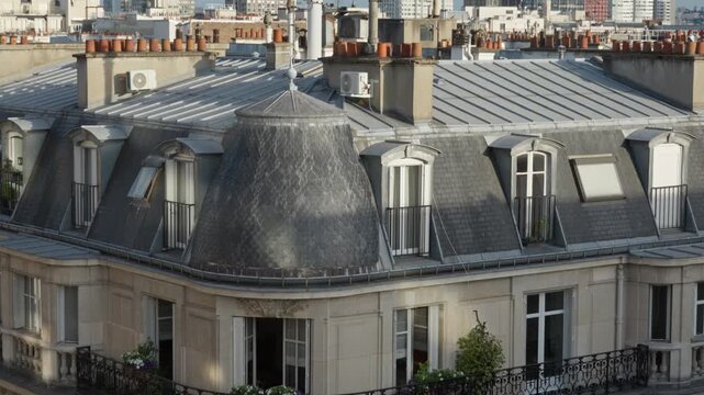 Haussmann architecture residential apartment building facade showcases historical Paris real estate property heritage with zinc roof balcony structures and urban neighborhood infrastructure.