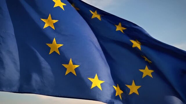 European Union flag waving in blue sky.