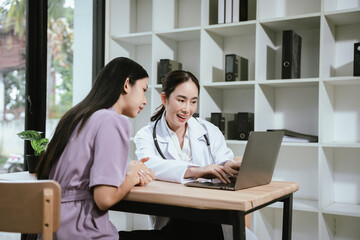 Fototapeta premium Female doctor consulting with a patient using a laptop in a modern clinic, discussing health information, treatment options, medical records, and personalized healthcare services.