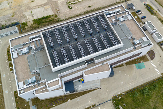 Aerial view of AI center with rows of cooling units on the roof and surrounding parking area in Warsaw, Masovian Voivodeship, Poland.