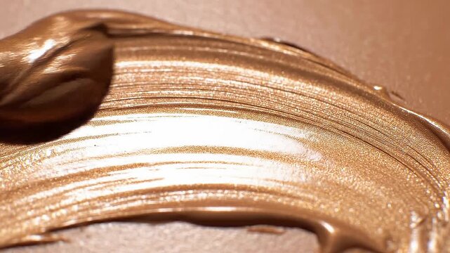 Motion of creamy white cosmetic texture smears concept. Close up of creamy bronze makeup foundation texture with smooth and shiny finish on skin