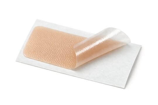 A piece of medical tape stuck to the top of a piece of paper, often used for temporary fixes or labeling
