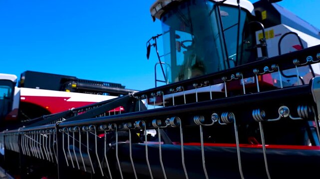 Harvester header details against blue sky.