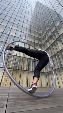 Dynamic and vibrant performance of a Cyr Wheel within urban architecture. Concept of individuality, creativity and self-confidence