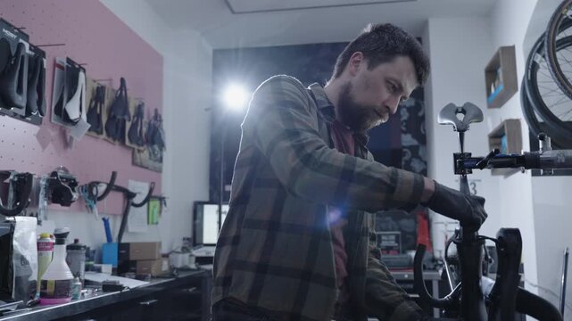 Mechanic in gloves repairs a premium carbon road bike, using professional tools in a dedicated workshop focused on high quality service and detailed component adjustments.