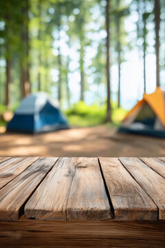 wooden table and blurry photos of camping and tents in the forest. vertical