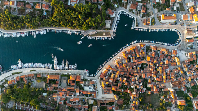 Aerial view of the historic town of Stari Grad, featuring terracotta rooftops and a harbour filled with boats along the Adriatic coastline. Stari Grad, Split-Dalmatia County, Croatia.