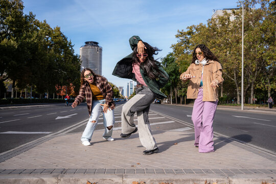 Gen-Z female urban dancer group performing on city street