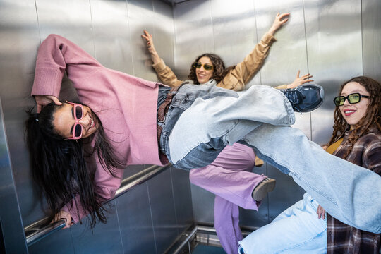 Gen-Z female urban dancers posing in a city elevator