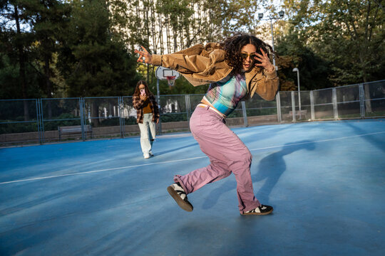Gen-Z female urban dancer performing on outdoor court
