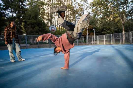 Gen-Z female urban dancers practicing breakdance outdoors