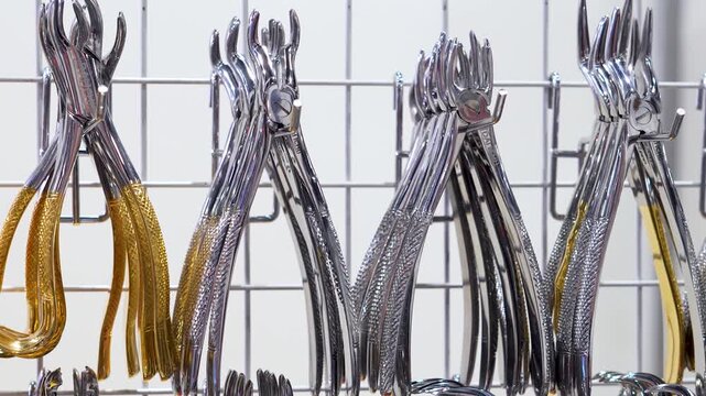 Dental pliers displayed in metal rows.