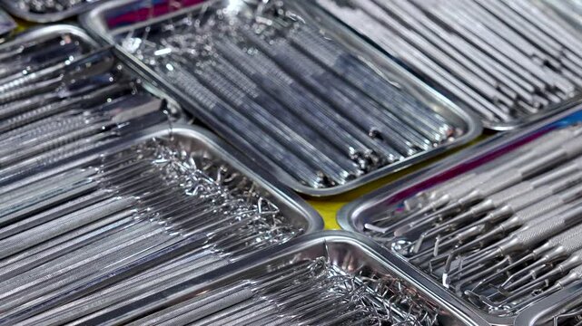 Dental instruments arranged in metal trays.